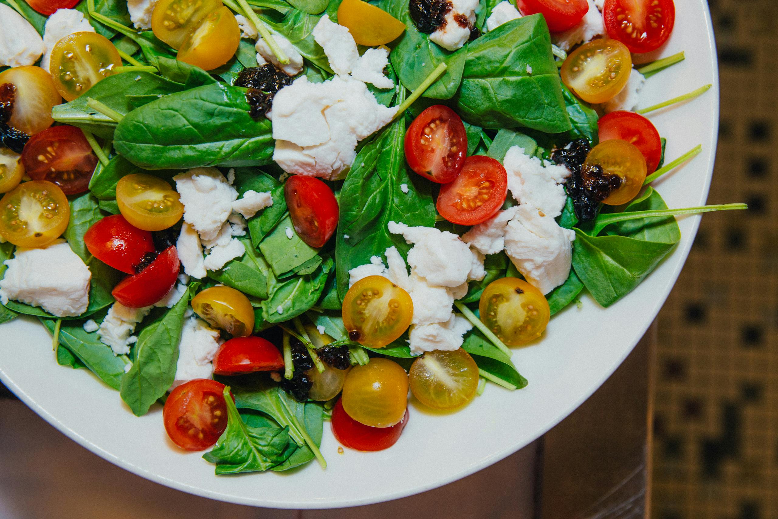 Delicious spinach caprese salad with cherry tomatoes and mozzarella, perfect for a healthy meal.